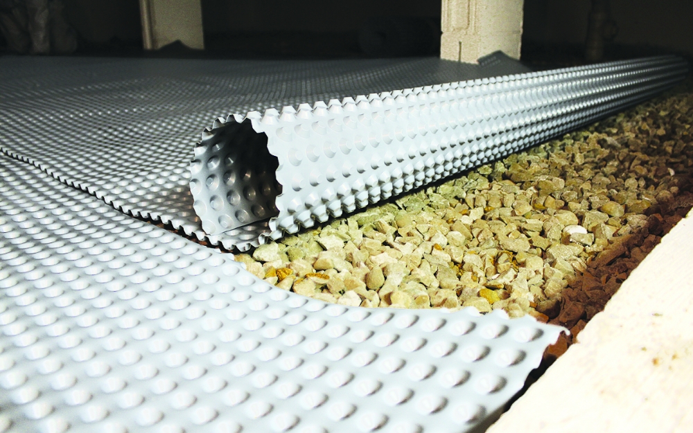 drain and dry rolling out a drainage mat over crawl space gravel | crawl space encapsulation | nash distribution