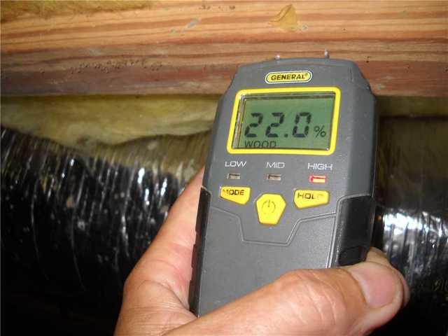 Moisture reading being performed in a crawlspace